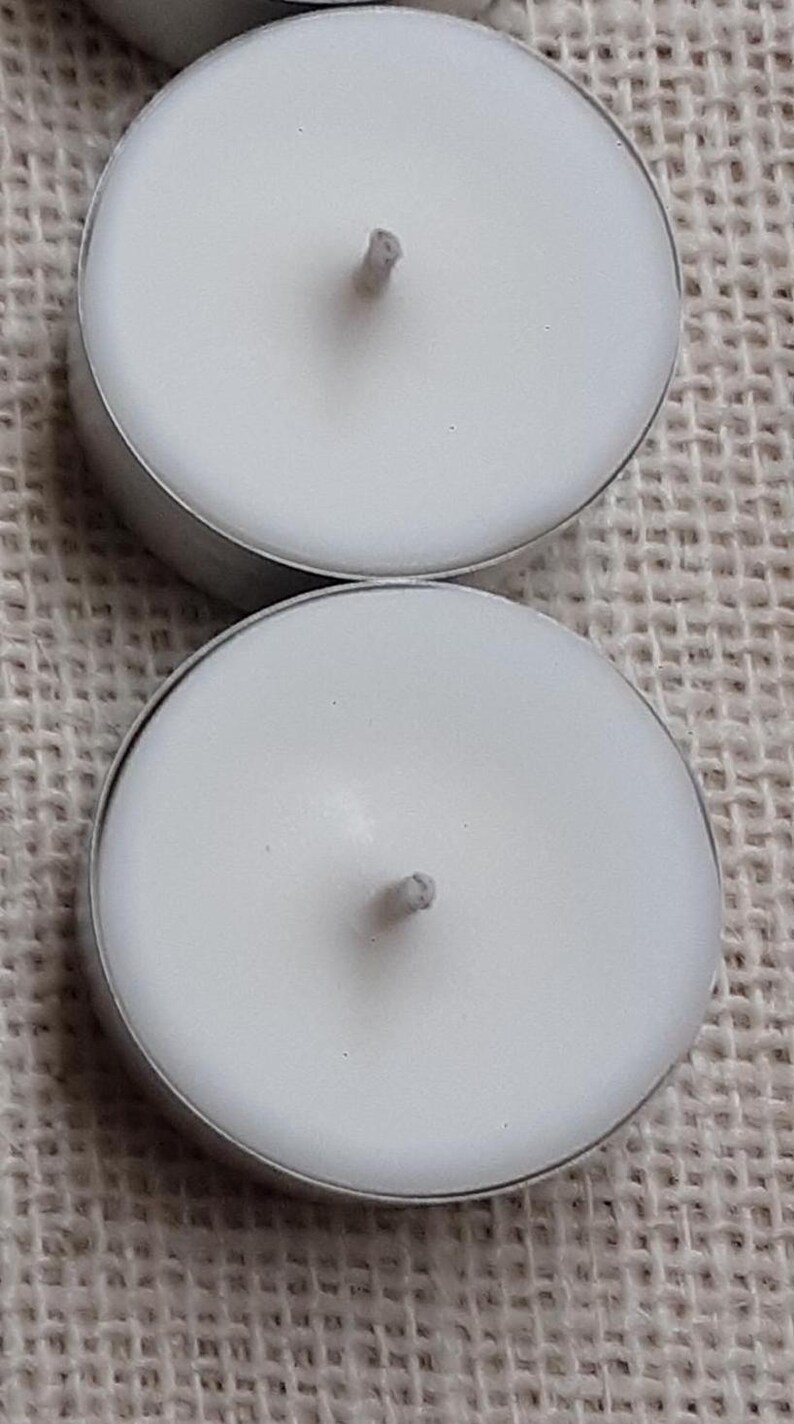 Puede incluir: Dos velas de t&eacute; blancas en portavelas plateados. Las velas son redondas y tienen una sola mecha en el centro.