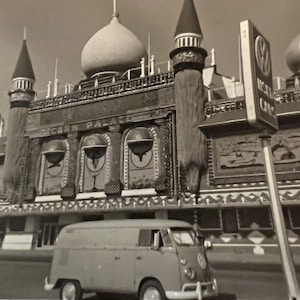 Könnte beinhalten: Schwarz-Weiß-Foto eines Gebäudes mit Kuppeldach und Türmchen. Ein klassischer Volkswagen-Transporter parkt davor. Ein Schild mit dem Volkswagen-Logo ist sichtbar. Der Name des Gebäudes ist "Michigan Palace".