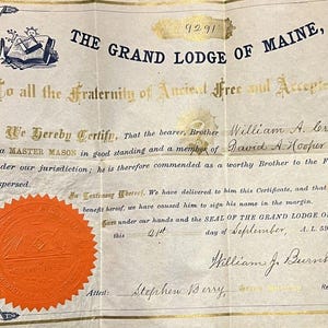May include: Antique certificate from The Grand Lodge of Maine, featuring ornate gold lettering and a large orange seal. The document certifies William A. Crabtree as a Master Mason, dated September 21, A.L. 5903, A.D. 1903.