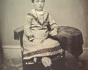 Grote tintype-foto van een Victoriaans meisje met gekruiste benen.