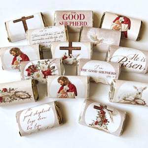 May include: A collection of chocolate bars with religious-themed wrappers. The wrappers feature images of a cross, Jesus, a lamb, flowers, and text such as "The Good Shepherd" and "He is Risen."