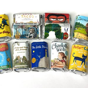 May include: A collection of wrapped candy bars featuring book covers. Titles include "Curious George", "Where the Wild Things Are", "The Very Hungry Caterpillar", "The Gruffalo", "The Lorax", "Frog and Toad Are Friends", "The Little Prince", "Charlotte's Web", and "Pete the Cat".