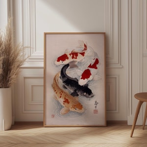 Pode incluir: Uma impressão emoldurada com quatro carpas koi em um arranjo circular. Os peixes são em tons de vermelho, preto e laranja, em um fundo azul claro. A obra de arte tem uma estética tradicional japonesa.