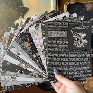 May include: A fan of rectangular paper cards featuring dark, botanical, and vintage-inspired illustrations. The top card displays a black background with white text that reads LISTEN AS THE EARTH SPEAKS, accompanied by a detailed mushroom graphic.