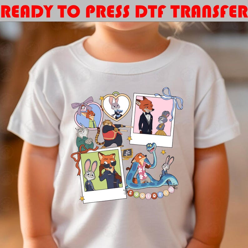 以下が含まれることがあります： ズートピアのカラフルな漫画のキャラクターが描かれた白いTシャツ。デザインには、ニック・ワイルドとジュディ・ホップスの額縁画像、その他のキャラクターが含まれています。「READY TO PRESS DTF TRANSFER」というテキストが上部にあります。