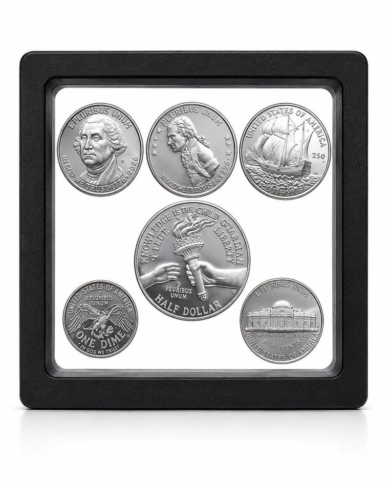 May include: A black square floating display frame containing five silver-toned coins. The coins feature various designs including George Washington, a ship, a torch held by two hands with the text KNOWLEDGE IS THE CHILD OF LIBERTY, a dime, and Monticello.