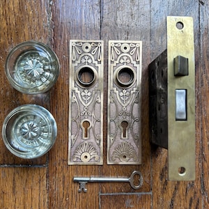 "Antike Türbeschläge mit runden Glasknöpfen und Messingplatten im ""Cambride"" Design von Lockwood."