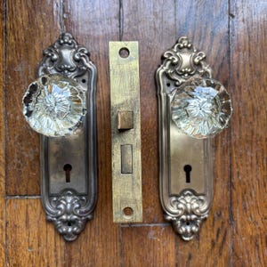 Antieke art nouveau-deurbeslag met gecanneleerde glazen deurknoppen, messing achterplaten