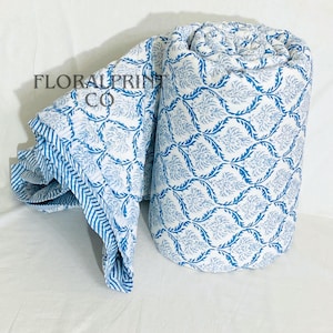 Reversible floral quilt made from soft cotton with traditional block print artistry. Designed as a lightweight comforter blanket that works beautifully in all seasons. Use it on a bed, sofa, reading chair, or daybed for cozy comfort and elegant style. Handmade details and breathable fabric make this quilt both practical and decorative for modern or boho home interiors.