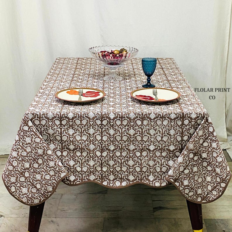 Beautiful Mud Brown floral block print tablecloth made from 100% pure cotton featuring traditional Indian hand block printing artistry. The rectangular dining table cover is styled with ceramic dinnerware, candles, and natural décor accents to create a welcoming boho farmhouse tablescape ideal for holiday dinners, wedding décor, brunch parties, and elegant indoor dining spaces with a rustic vintage touch.