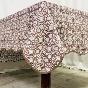 Floral Mud Brown block print tablecloth with elegant piping edges displayed in a neutral farmhouse dining room setting. Crafted from soft durable cotton, this handcrafted rectangular table cover offers a cozy bohemian feel ideal for wedding table styling, Thanksgiving dinners, festive occasions, rustic parties, and everyday dining room decoration with timeless artisan appeal.