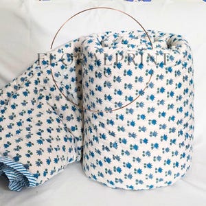 Cotton handmade quilt with floral block printed patterns on both sides, offering a reversible bedspread style for versatile décor. Soft and airy construction makes it ideal for spring, summer, autumn, and mild winter layering. Perfect for bedrooms, couch naps, guest rooms, or travel stays. A charming handcrafted blanket that brings warmth and artisan beauty to your home.