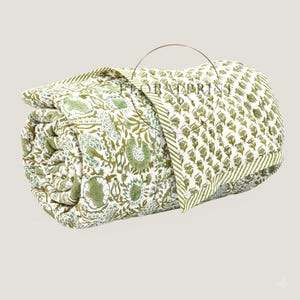Floral cotton quilt handmade with traditional block printing and detailed stitching. Reversible construction provides two patterns in one elegant blanket. Lightweight yet cozy, it is perfect for layering on your bed or curling up on the couch. The breathable cotton fabric offers comfort year-round, making it a practical and stylish addition to farmhouse, bohemian, or classic décor.