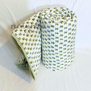 Reversible handmade quilt in cotton featuring elegant floral block printed patterns and a cozy lightweight fill. Great as a bedspread, couch throw, or extra comforter for overnight guests. Breathable material makes it comfortable during warm nights while still useful for layering in cooler months. A lovely handcrafted accent for any bedroom or living room.