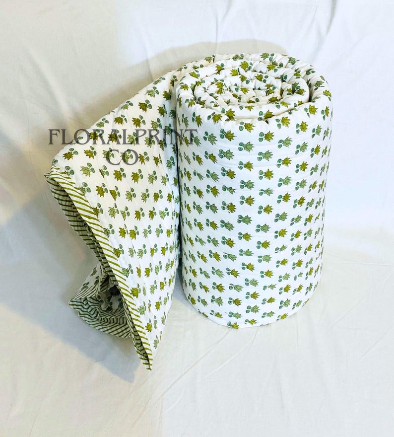Reversible handmade quilt in cotton featuring elegant floral block printed patterns and a cozy lightweight fill. Great as a bedspread, couch throw, or extra comforter for overnight guests. Breathable material makes it comfortable during warm nights while still useful for layering in cooler months. A lovely handcrafted accent for any bedroom or living room.