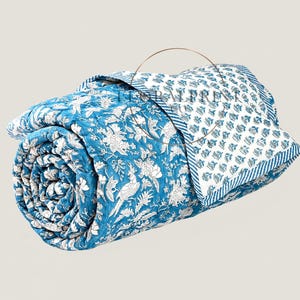 Handmade cotton block printed quilt featuring beautiful floral patterns and a reversible design for two stylish looks in one. Soft, lightweight, and comfortable for year-round use on your bed, couch, or guest room. This artisan quilt adds warmth, color, and handcrafted charm to any space while offering breathable comfort for every season. Perfect for layering or using as a decorative bedspread.