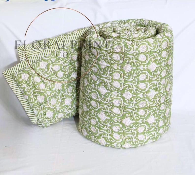 Soft lightweight comforter blanket crafted from cotton and decorated with hand block printed floral motifs. Reversible design lets you refresh your room instantly with two lovely sides. Suitable for beds, couches, picnic use, or cozy evenings indoors. Breathable and comfortable through every season, this handmade quilt is a thoughtful housewarming or wedding gift.