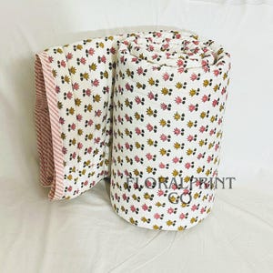 Cotton block print bedspread with reversible floral sides, offering two decorative looks for your room. Handmade with soft fabric and lightweight comfort for daily use in every season. Ideal for sleeping, lounging, travel, or guest accommodations. This quilt blends traditional craftsmanship with modern practicality, making it a beautiful addition to any cozy living space.