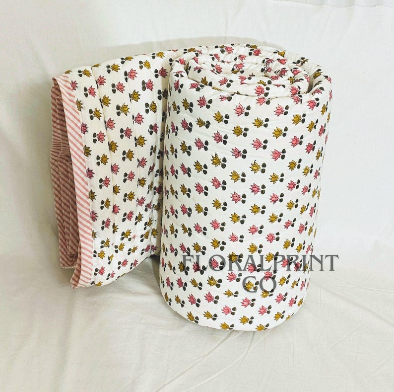 Cotton block print bedspread with reversible floral sides, offering two decorative looks for your room. Handmade with soft fabric and lightweight comfort for daily use in every season. Ideal for sleeping, lounging, travel, or guest accommodations. This quilt blends traditional craftsmanship with modern practicality, making it a beautiful addition to any cozy living space.