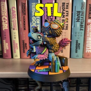 May include: A colorful fantasy figurine featuring a dinosaur riding a furry creature, with bottles and a suitcase on a patterned base. The figurine is in front of a shelf of books with titles like "Dungeon Crawler" and "This Inevitable Ruin."