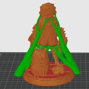 Op de afbeelding: Een 3D-geprinte figuur met een figuur met een vloeiende jurk, een kat en een kleine schedel. De figuur is bruin met groene ondersteuningsstructuren. De basis is rood en cirkelvormig.