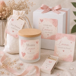 Könnte beinhalten: Eine Kerze im Milchglas mit Holzdeckel, eine weiße Geschenkbox mit rosa Schleife, ein Beutel mit Anhänger For Emma, with love, eine Streichholzschachtel mit A little love und eine Karte mit Emma, you are so loved, verziert mit rosa Herzen.
