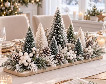 May include: A rectangular wooden centrepiece featuring a collection of miniature flocked green and white bottle brush trees, natural pinecones, white berry clusters, and frosted evergreen sprigs arranged on a long, narrow wooden base.