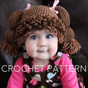 And adorable blue-eyed baby girl is wearing a crochet hat that looks like the yarn hair of a Cabbage Patch Kid doll from the 1980s. It has 2 pigtails and loopy bangs. The photo indicates this is for the crochet pattern to make this hat.