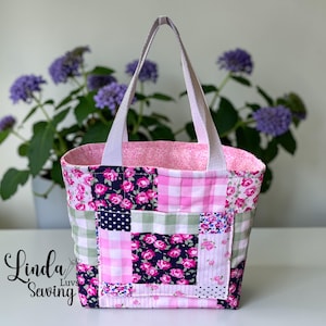 May include: A patchwork tote bag with a variety of floral, gingham, and polka dot patterns in pink, navy, and white. The bag has a light pink interior and white handles. The text "Linda Luvs Sewing" is visible on the lower left.