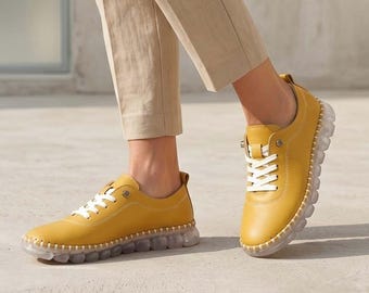 Zapatillas deportivas de cuero amarillo hechas a mano para mujer: calzado cómodo y elegante.