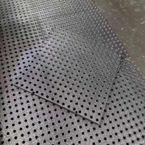 May include: Two black, textured sheets with a pattern of evenly spaced, small holes. The sheets have a slightly reflective surface and appear to be made of a durable material. The sheets are placed on a dark surface.
