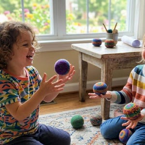 May include: Two children are playing with colorful, knitted balls. One child holds a purple ball, while the other holds a ball with stripes of orange, blue, and green. Other balls are on a small wooden table.