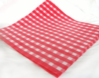 May include: Red and white checkered paper, folded in half, with a white background.