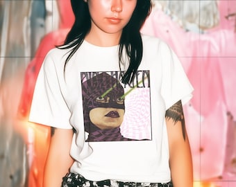 May include: A white short-sleeve t-shirt featuring a graphic print of a person wearing a purple patterned balaclava with green laser beams emitting from their eyes. The shirt is paired with black and white floral print shorts and fishnet stockings.