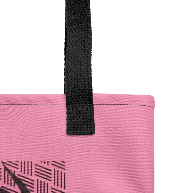 Pu&ograve; includere: Una borsa tote rosa con un motivo grafico nero in stile intrecciato sulla parte inferiore. La borsa presenta una spessa tracolla in tessuto nero fissata al bordo superiore con cuciture visibili lungo la giuntura con il materiale rosa.