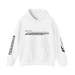 Könnte beinhalten: Weißer Kapuzenpullover mit Kängurutasche vorne, Kordelzugkapuze und schwarzem Text "Ferrari 499P". Der linke Ärmel hat das Wort "Tonnani" vertikal in Schwarz aufgedruckt. Der rechte Ärmel hat eine schwarze Grafik.