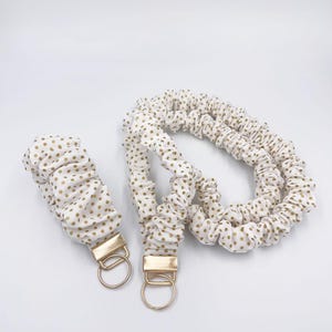 May include: A white ceramic mug with a black handle and the text "But First, Coffee" in a bold, black font. The mug is set against a neutral background, highlighting its simple design.