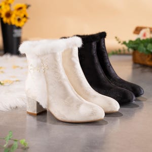 Peut inclure: Une paire de bottines, une cr&egrave;me et une noire, pr&eacute;sentant un motif floral subtil, un talon bloc et une bordure en fausse fourrure douce sur le haut. La botte cr&egrave;me comporte un d&eacute;tail de n&oelig;ud en tissu d&eacute;coratif sur le c&ocirc;t&eacute; pr&egrave;s de l'ouverture.