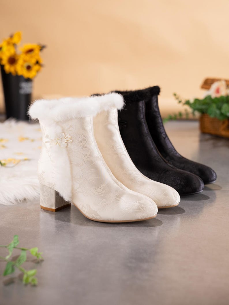 Peut inclure: Une paire de bottines, une cr&egrave;me et une noire, pr&eacute;sentant un motif floral subtil, un talon bloc et une bordure en fausse fourrure douce sur le haut. La botte cr&egrave;me comporte un d&eacute;tail de n&oelig;ud en tissu d&eacute;coratif sur le c&ocirc;t&eacute; pr&egrave;s de l'ouverture.