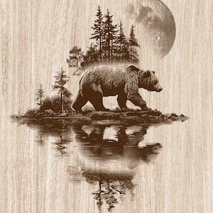 以下が含まれることがあります： 木目調の茶色の表面に、岸辺を歩くクマのダークブラウンの彫刻イラストが描かれています。この風景には松林、空に浮かぶ大きな満月、そして水面に映るクマと木々の鮮明な反射が含まれています。