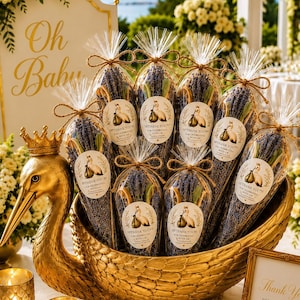May include: A gold-colored swan-shaped bowl holds several clear plastic bags filled with dried purple lavender sprigs. Each bag is tied with twine and features a circular white sticker with a swan illustration and the text Thank You For Celebrating With Us.