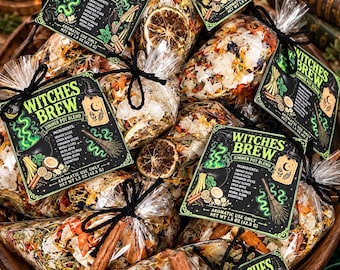 Può includere: Diverse bustine di plastica trasparente contenenti una miscela per pentola a fuoco lento Witches Brew, ciascuna con un'etichetta nera con testo e illustrazioni verdi. Il contenuto include fette d'arancia, cannella, chiodi di garofano e mela essiccati, con un peso netto di 42,5 g.