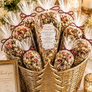 May include: A gold-colored woven basket containing multiple clear plastic cones filled with a dried botanical simmer blend. Each cone is tied with a dark red string and features a label reading Winter Wonderful Simmer Blend.