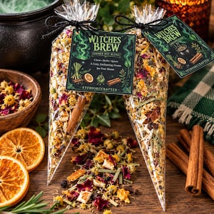 May include: Two clear cone-shaped bags filled with Witches Brew simmer pot blend, featuring dried citrus, herbs, and spices. Each bag has a black tag with green text reading Witches Brew Simmer Pot Blend, Citrus, Herbs, Spices, and StudioKCCrafted.