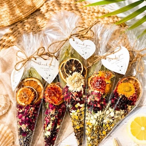 May include: Five clear cone-shaped plastic bags filled with dried flower petals, herbs, and dried citrus slices. Each bag is tied with brown twine and features a white heart-shaped tag with the text thank you for celebrating with us.