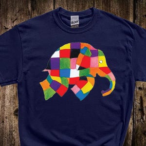 Könnte beinhalten: Marineblaues T-Shirt mit einem farbenfrohen Patchwork-Elefanten-Design. Der Elefant besteht aus verschiedenen Quadraten in Rot-, Gelb-, Grün-, Lila- und Blautönen. Das Shirt hat einen klassischen Rundhalsausschnitt und kurze Ärmel.