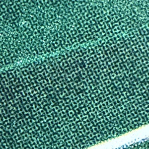 Op de afbeelding: Close-up van een getextureerde, teal-kleurige stof met een herhalend patroon van kleine, donkere vierkanten. Een dunne, witte streep met een vleugje blauw loopt diagonaal over de rechter benedenhoek van de afbeelding.