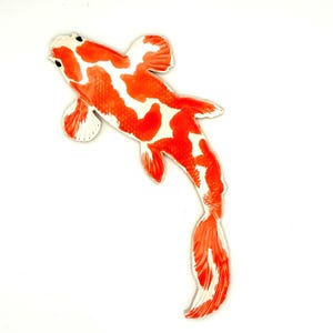 May include: A decorative koi fish with a vibrant orange and white pattern. The fish is depicted from above, showcasing its detailed fins and tail against a white background. The design is reminiscent of traditional Japanese art.