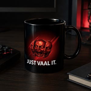 May include: A black ceramic mug featuring a graphic of three red, distressed faces arranged in a cluster against a red glowing background. Below the graphic, the text "JUST VAAL IT." is printed in a bold, white, sans-serif font.