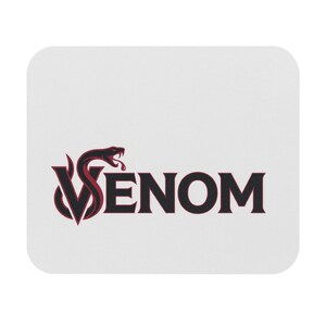 Op de afbeelding: Een rechthoekige witte muismat met een zwart en donkerrood grafisch logo. Het ontwerp bevat een gestileerde letter V in de vorm van een slang met een open bek en giftanden, gevolgd door het woord VENOM in dikke, zwarte schreefletters.